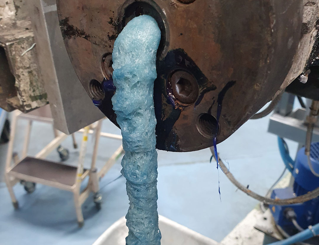 Blaue Auschüsse die bei Kunstofftechnik aus einer Maschine herauskommen